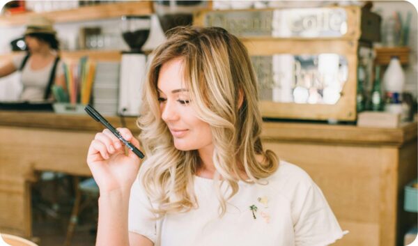 A women sitting at a desk holding a pen creating authentic content for her blog while balancing trends.